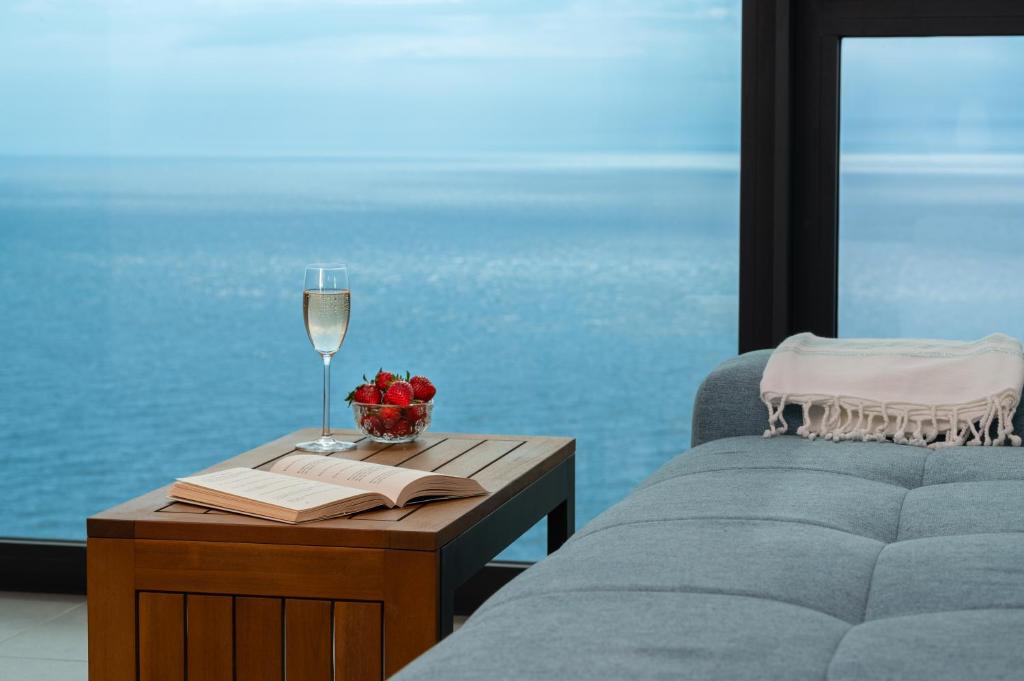 a bedroom with a couch and a table with a glass of wine at Calithea Residence in Kavarna
