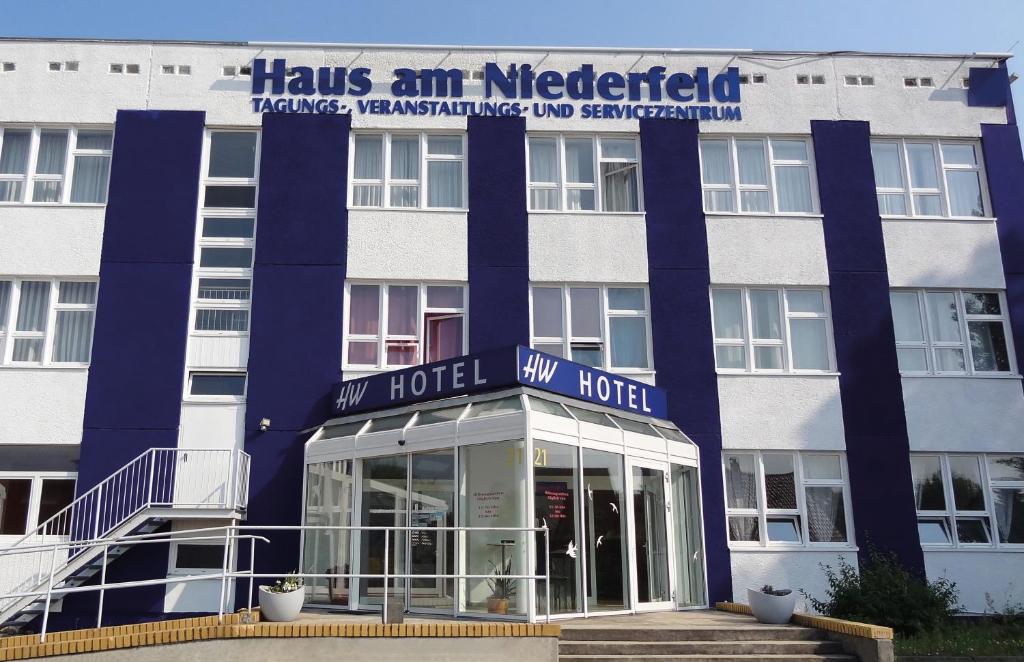 a hotel with a blue sign on the front of it at HW Hotel - Haus am Niederfeld in Berlin