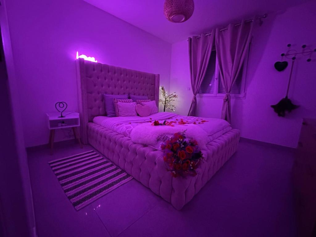 a purple bedroom with a bed with a purple lighting at Suite Jacuzzi Giverny Paris in Freneuse