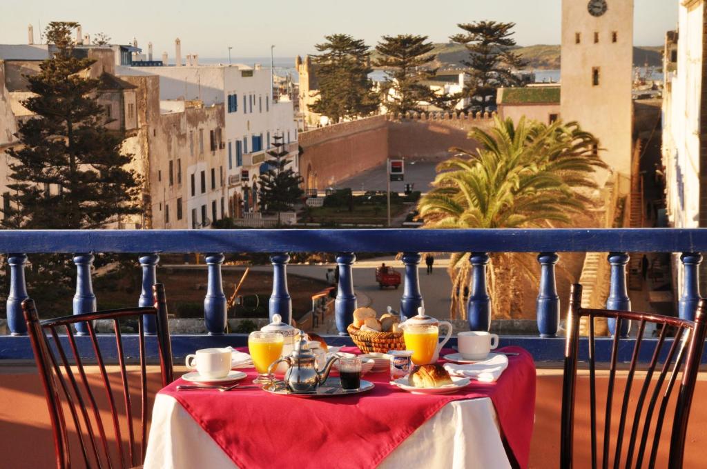 a table with drinks on a balcony with a view at Essaouira Wind Palace in Essaouira