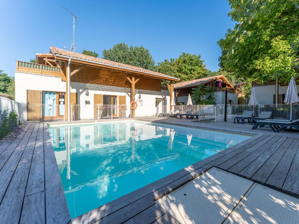a swimming pool in front of a house at Vacancéole - Les Rives du Lac in Lacanau