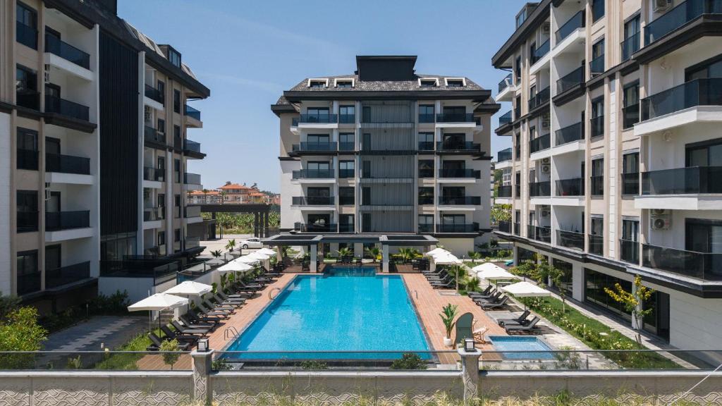 an apartment with a swimming pool and two buildings at Eliz Paradise By Panjur in Alanya