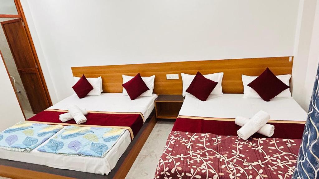 two beds in a room next to each other at Shreevanya Inn in Ayodhya