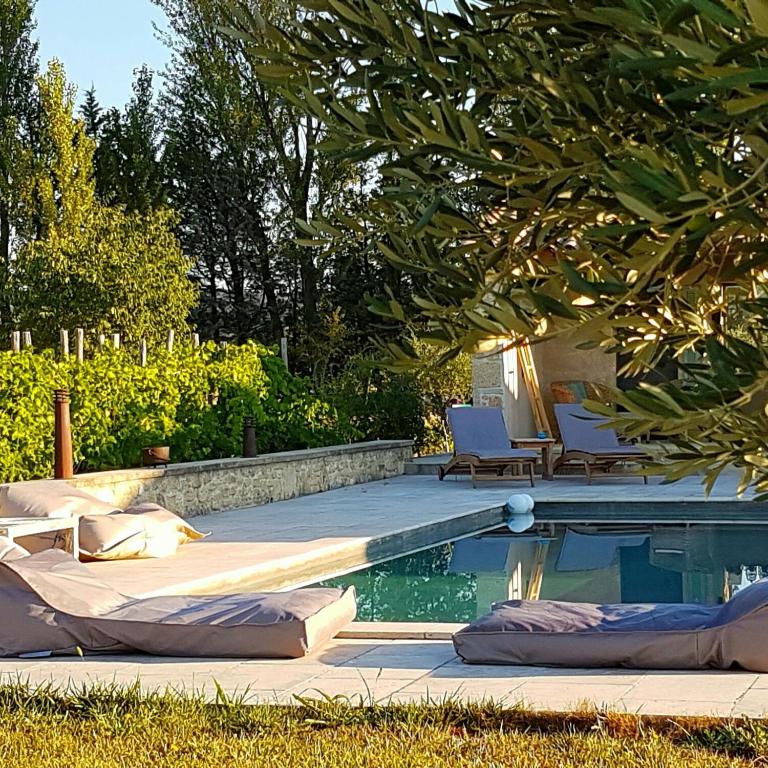 - une piscine avec des oreillers dans une cour dans l'établissement Fontaine de Cérier, à Castillon-du-Gard