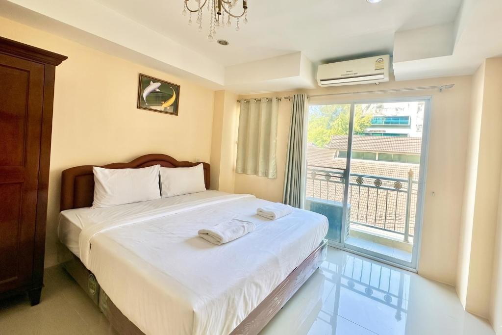 a bedroom with a bed and a large window at P ratunam Residence Hotel in Bangkok