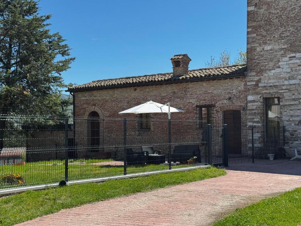 an umbrella in front of a brick building at La torre del cappellaio in Fabriano