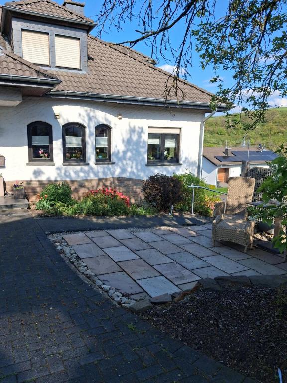 a white house with a bench in front of it at Ferienwohnung Wirtz in Olzheim
