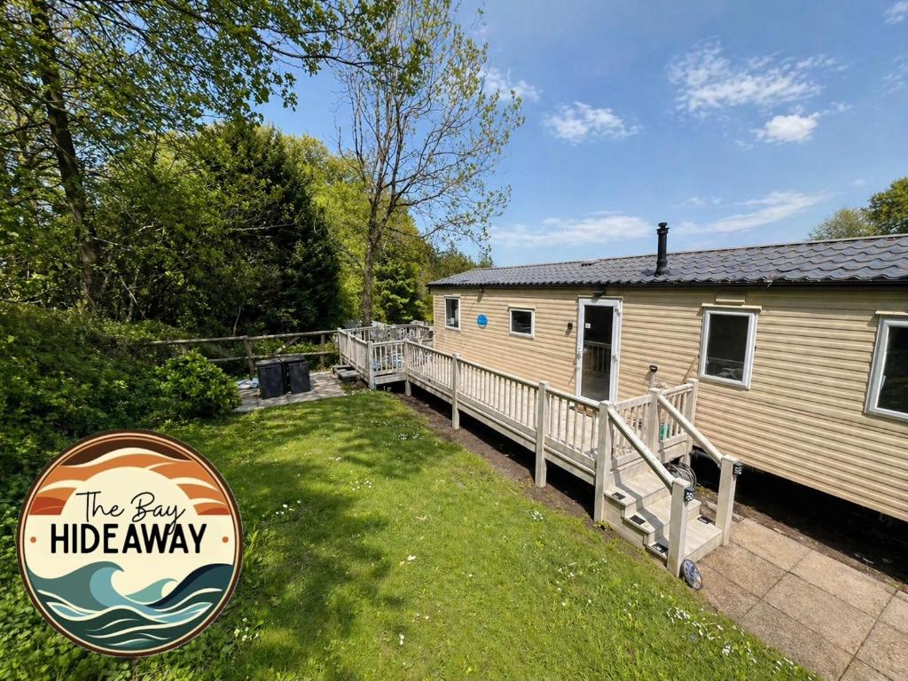 a mobile home with a deck next to a house at The Bay Hideaway in Bucks Mills