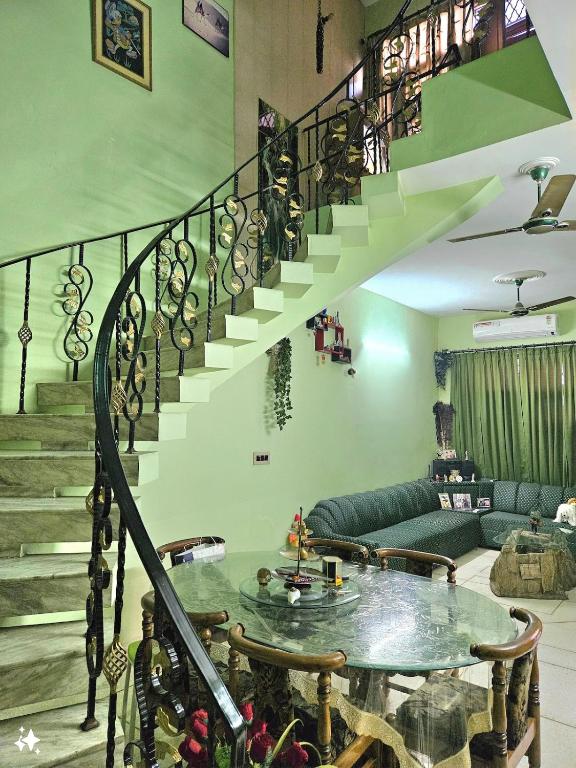 a living room with a staircase and a table at The Green Villa in Ludhiana