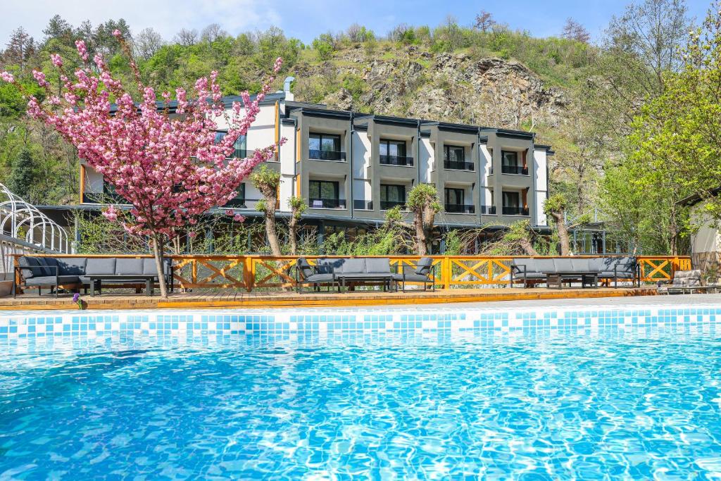 a hotel with a pool in front of a building at Комплекс РАЙ in Ognyanovo