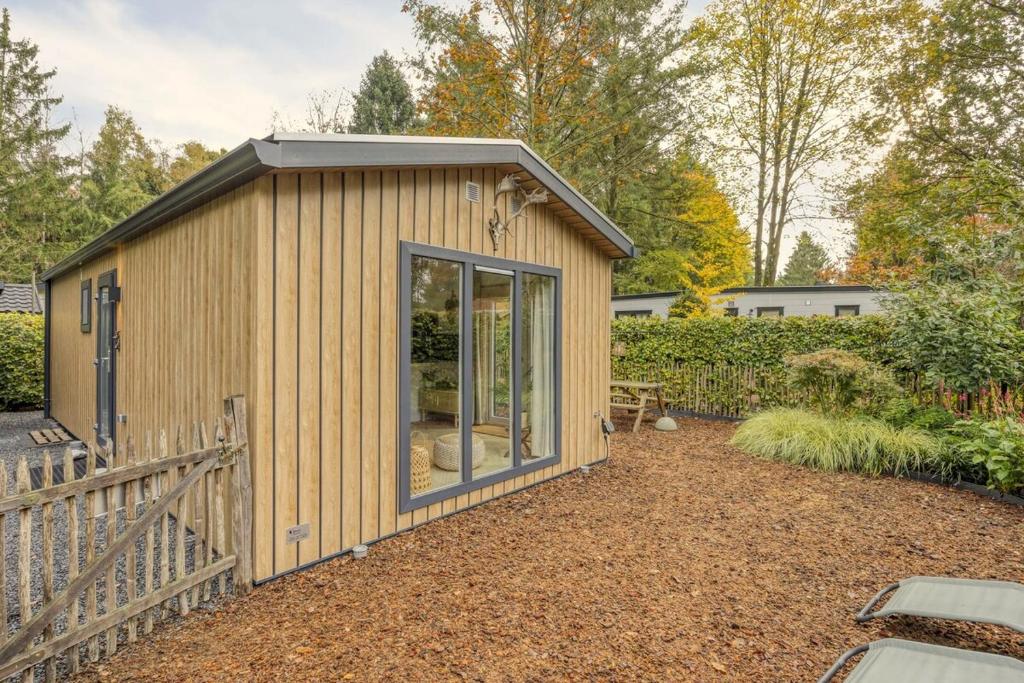 a small wooden shed with a pitched roof at Knusse Tiny house op de Veluwe in Epe