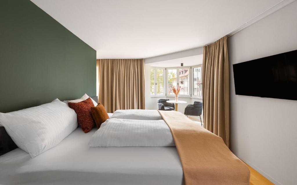 a bedroom with a large bed and a television at Moe by Limehome in Freudenstadt