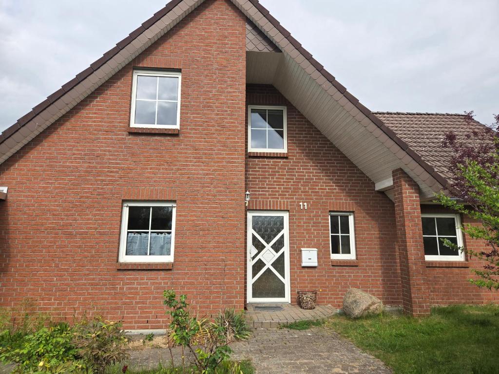 a red brick house with a white door at Monteuerwohnung in ruhiger Lage in Möser