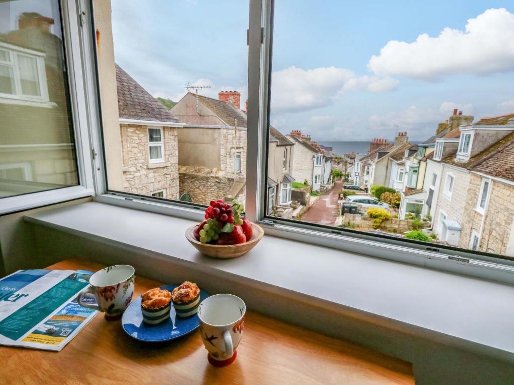 a window sill with a plate of food and two cups at Seaview Portland in Portland