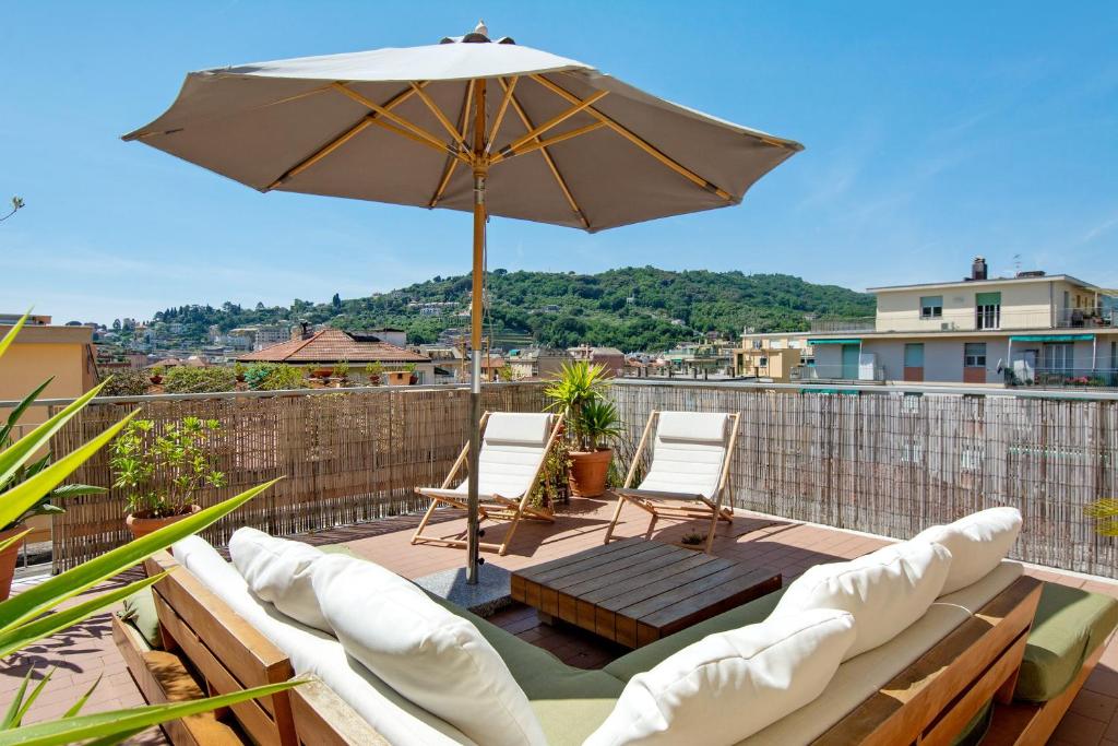 a patio with two chairs and an umbrella at Casa La Perla in Rapallo