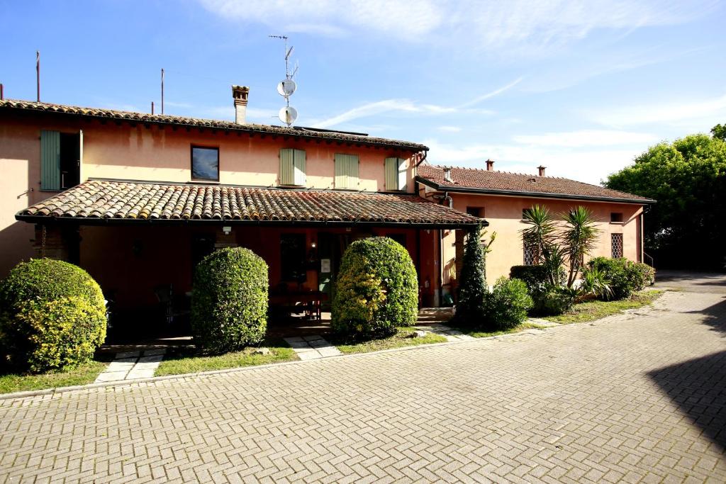 a house with hedges in front of a driveway at Affittacamere San Cristoforo Faenza in Faenza