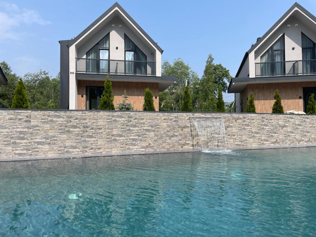 a house with a swimming pool in front of a house at Tatariv-hills in Tatariv