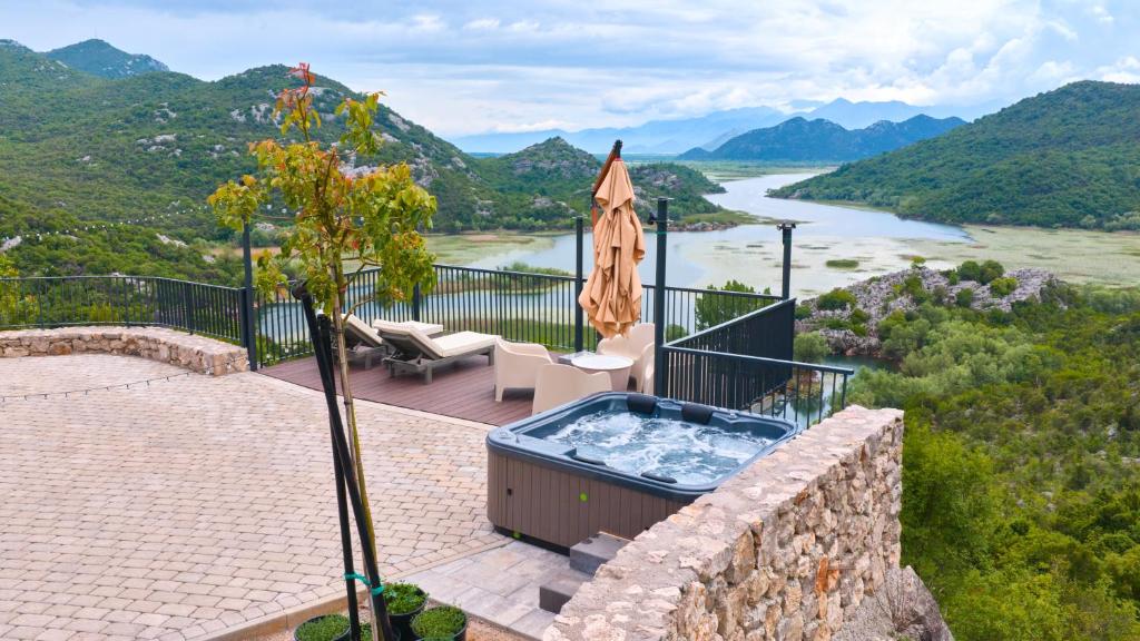 a patio with a hot tub and an umbrella at Skyline Skadar Lake in Karuč