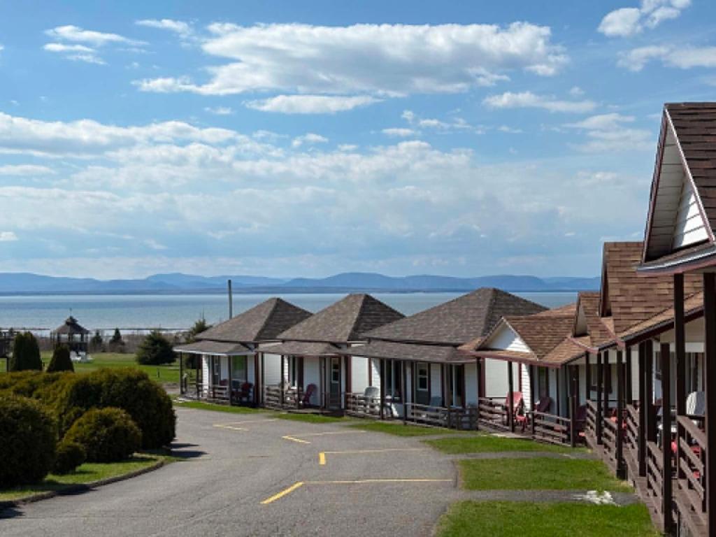 a row of houses with the ocean in the background at Motel au Fleuve d'Argent in Rivière-du-Loup