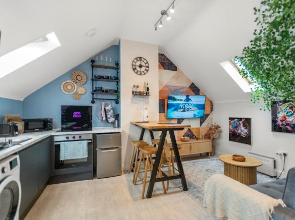 a kitchen and living room with a table in a room at Upbeat Jungle Loft Apartment in Derby