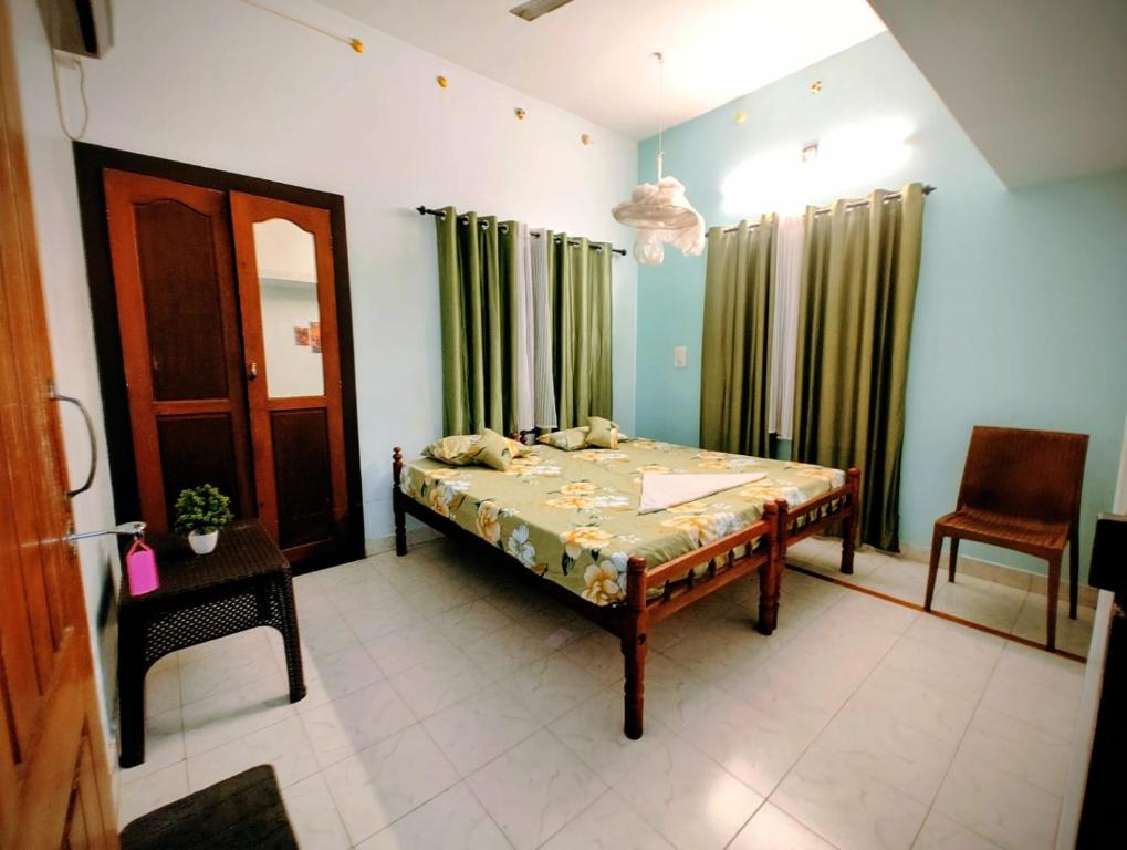 a bedroom with a bed and a table and a chair at Gothra Beach Casa in Alleppey