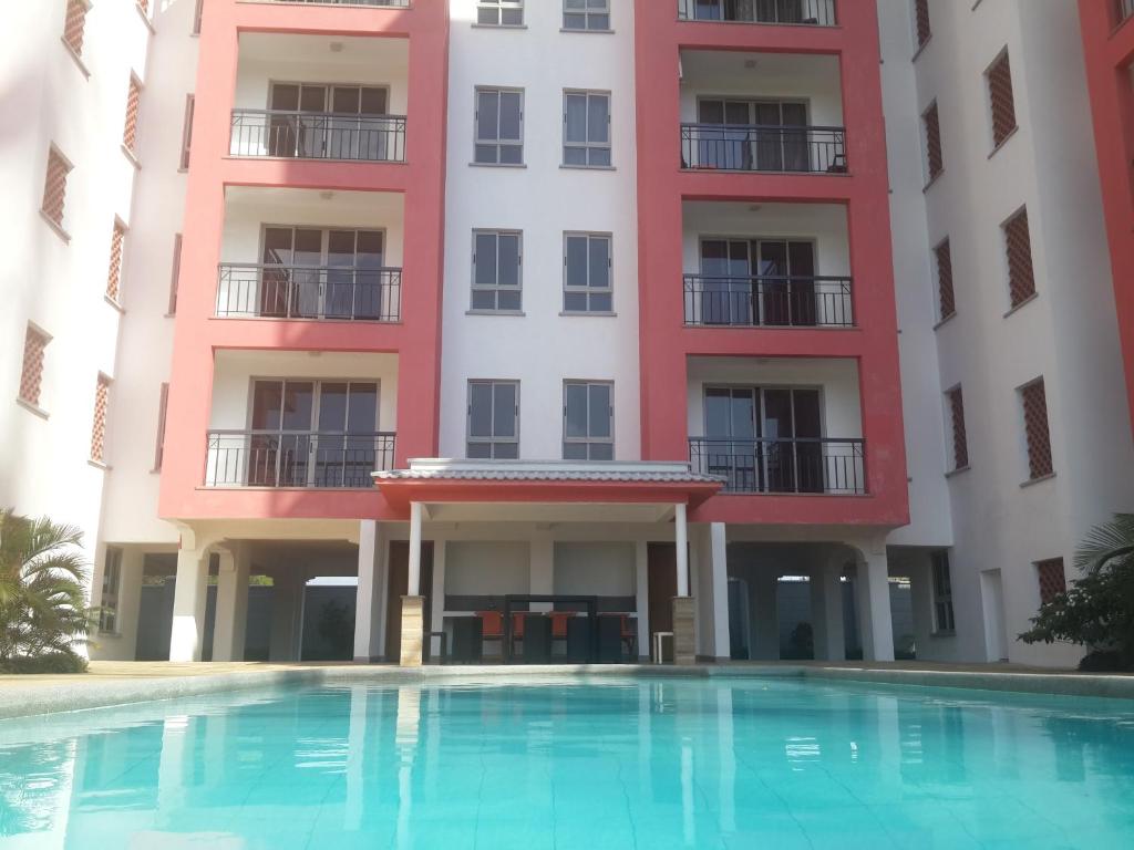 a building with a swimming pool in front of it at Shanzu Beach apartment with stunning Ocean view in Mwakirunge