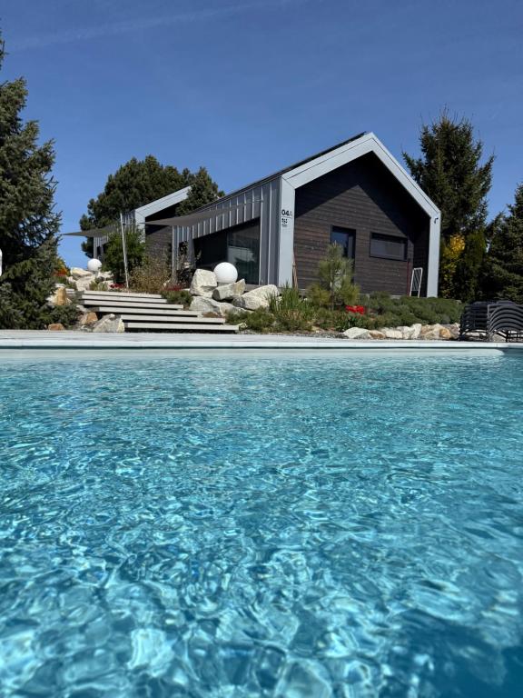 a house with a swimming pool in front of a house at SKARPA resort in Ustronie Morskie