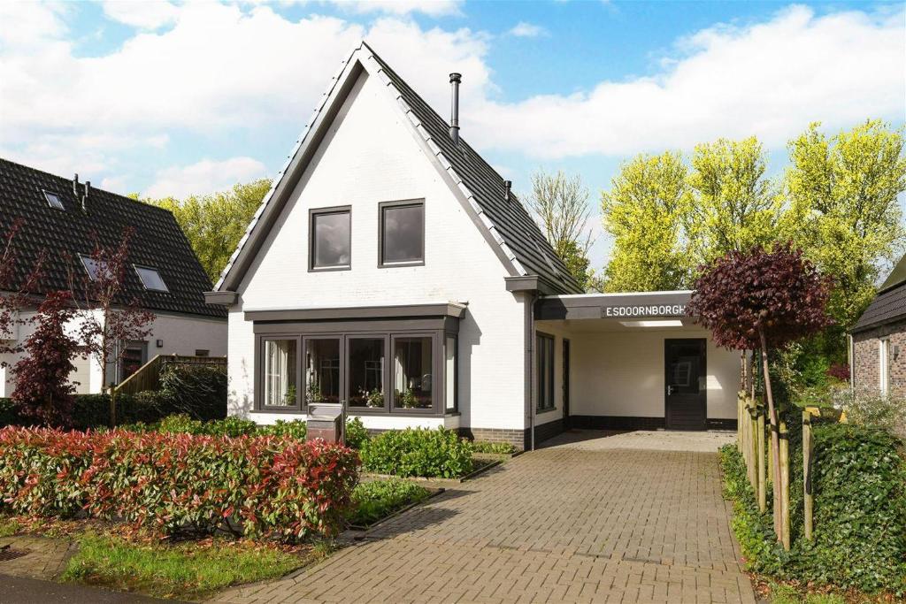 a white house with a black roof and a driveway at Villa Oasis in Lelystad