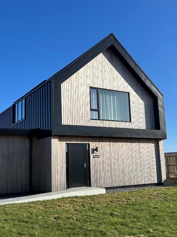 a house with a black roof and a black door at Kelsingra Self Catering in Lerwick/Tingwall Airport