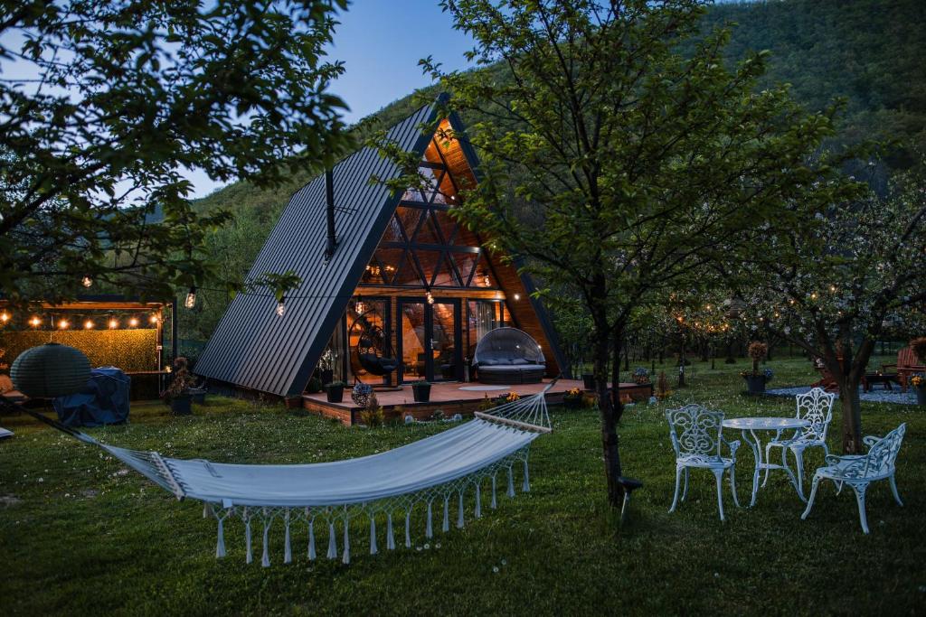 a tree house with a hammock in the yard at Cabana A-frame D&J in Mada