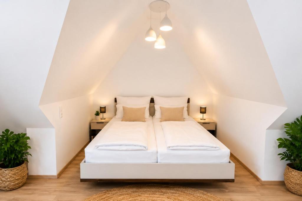 a white bed in a room with two plants at Ort 245 in Ried im Innkreis