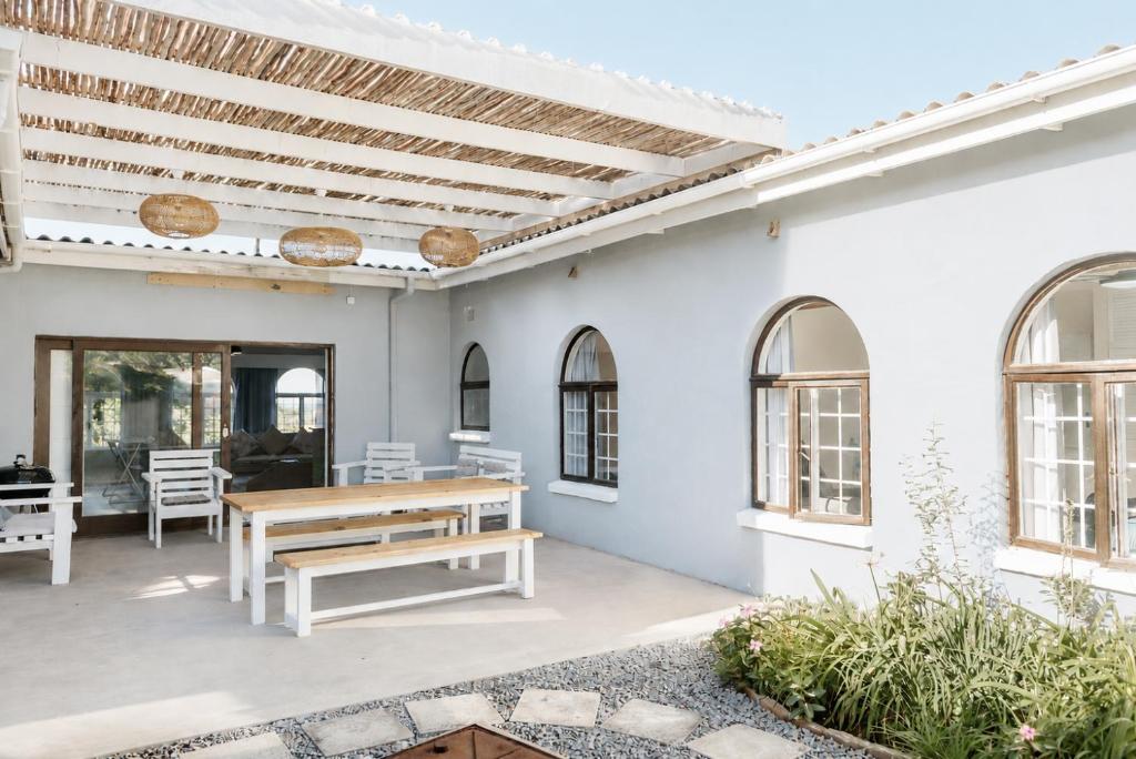 a patio with a wooden table and benches at Idylla Guest Home in Kenton on Sea