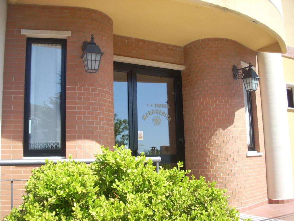 a brick building with two windows and two lights at Hotel Margherita in San Giovanni Rotondo