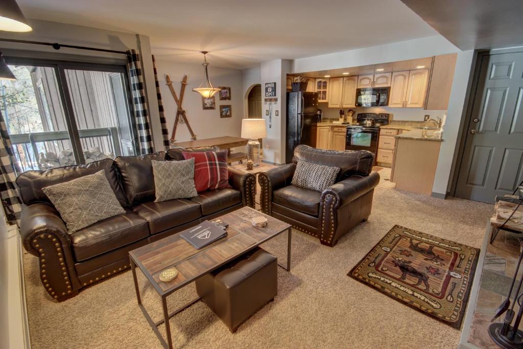 a living room with leather furniture and a kitchen at Wild Irishman 1059 by SummitCove Lodging in Colorado in Keystone