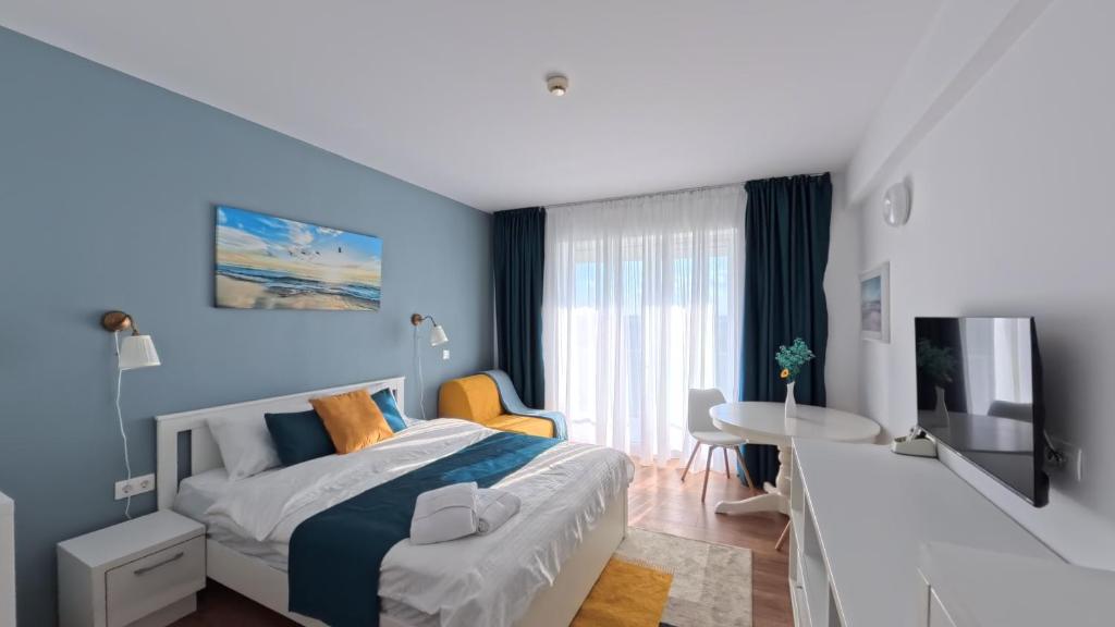 a bedroom with blue walls and a bed and a table at Cozy Studio Olimp in Olimp