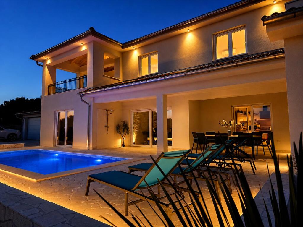a villa with a swimming pool at night at Villa Lumia in Banjol