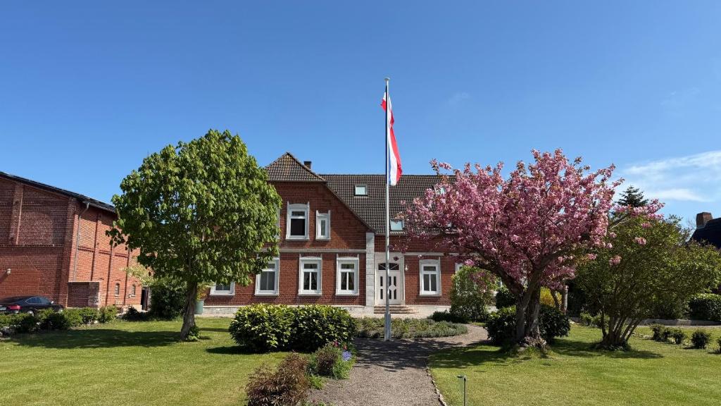 a red brick house with an american flag in front at Bauernhuus 6 in Fehmarn