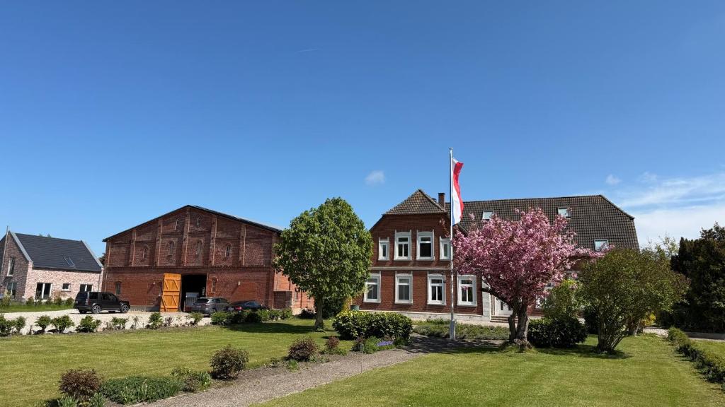a house with a flag in the middle of a yard at Bauernhuus 4 in Fehmarn