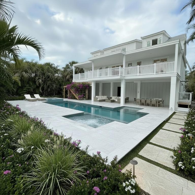 a white house with a swimming pool in front of it at Cabana Blu in Captiva