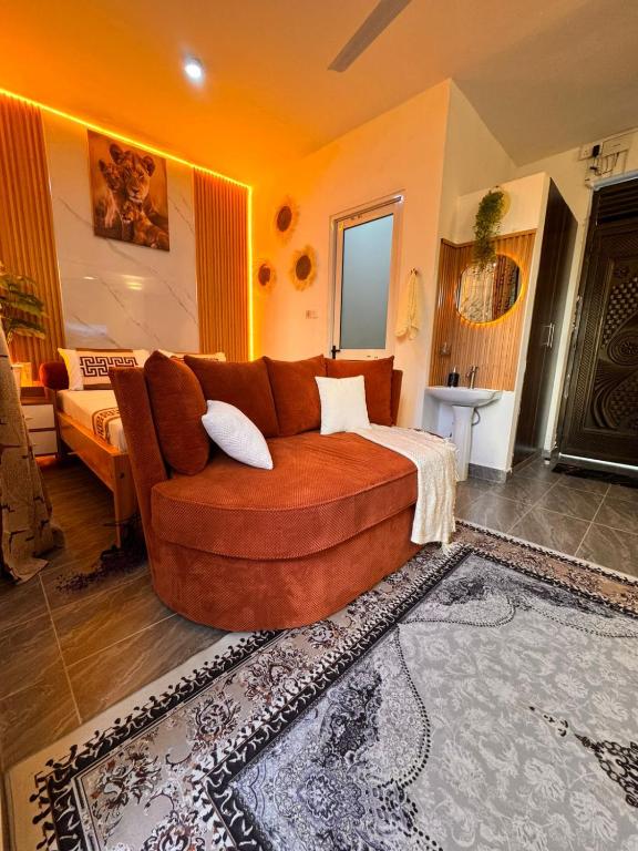 a living room with a brown couch in a room at Homes by Najma in Mtwapa