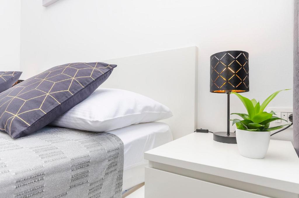 a bedroom with a bed and a table with a lamp at Apartments and Rooms Adriatic Suites in Šibenik