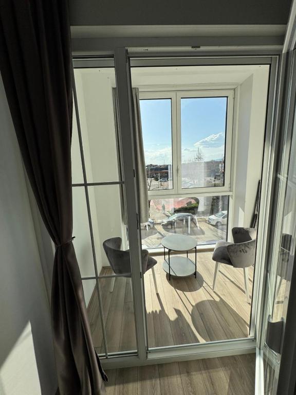 a room with a large window with a table and chairs at Apartman Mila in Trnava