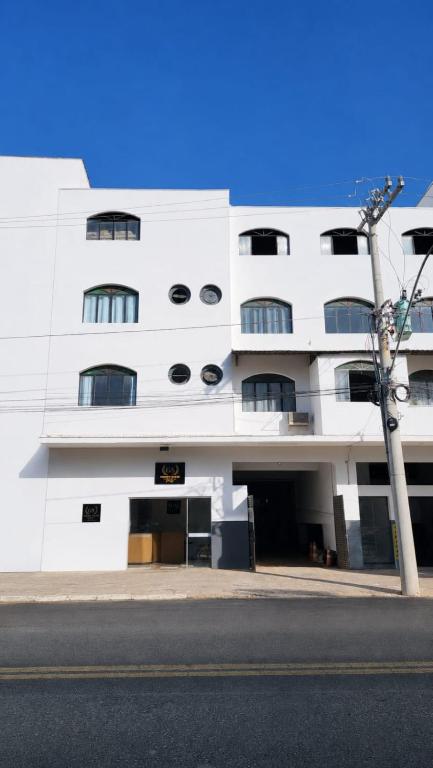a white building with windows on the side of it at Golden Silver UNIQUE in Curvelo
