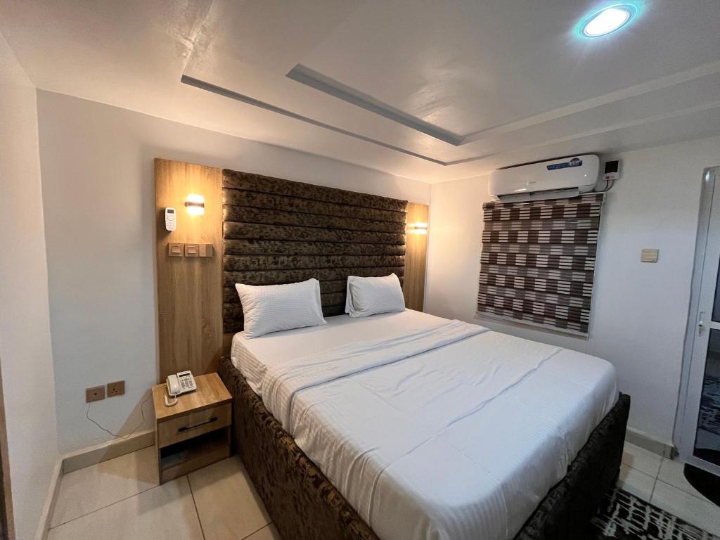 a bedroom with a large bed with a brick wall at Kelvin Cameo Resort Hotel in Madala