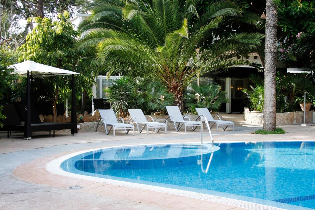 a swimming pool with lounge chairs and a pool at Morlans Garden in Paguera
