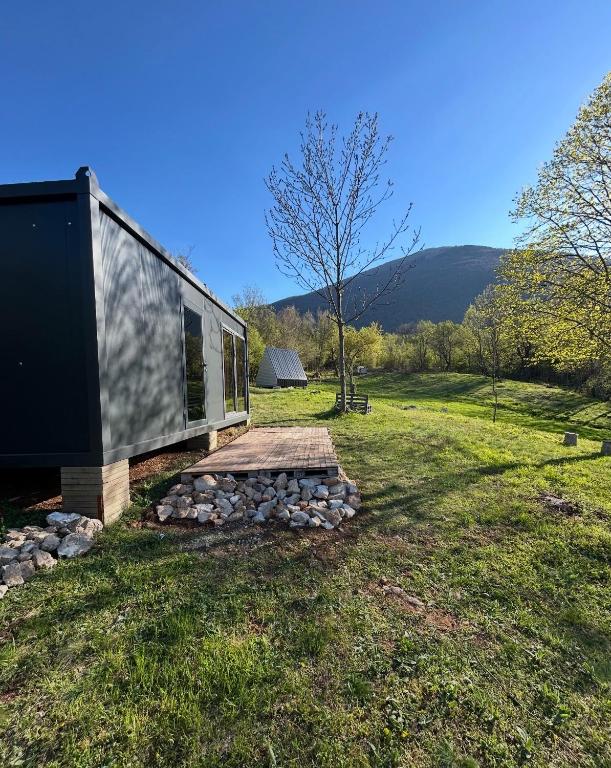 a house on a field with a stone walkway at OffGrid Retreat Rtanj in Boljevac
