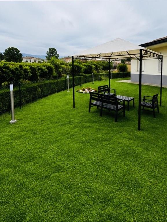a group of benches under a tent on a lawn at L'imbarco ROOMS in Badolato Stazione