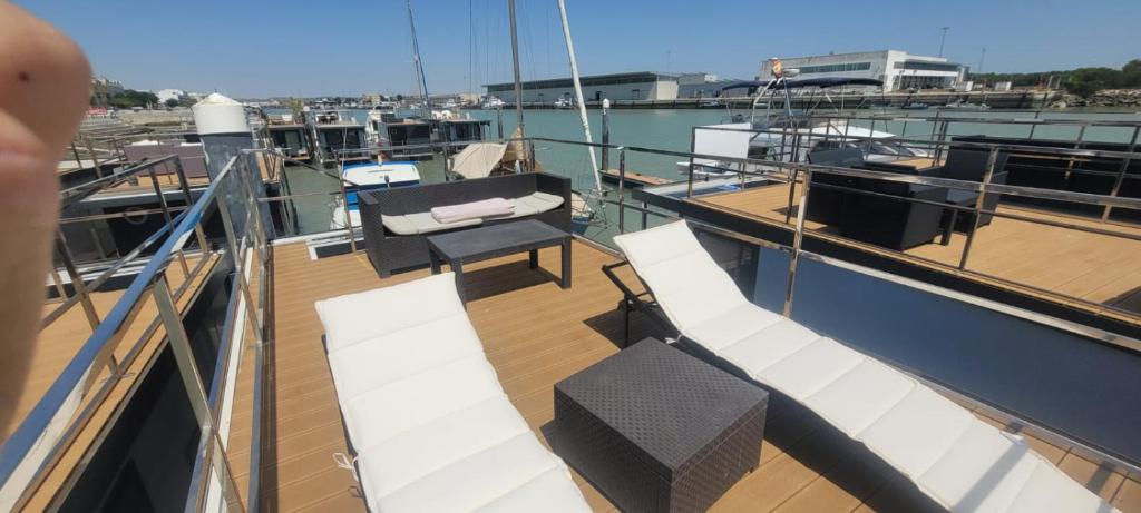 a deck of a boat with a table and chairs at SEA & SOUL SUITe in El Puerto de Santa María