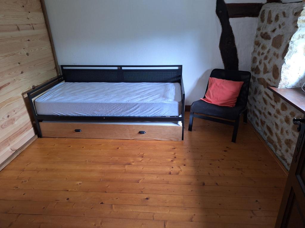 a small bedroom with a bed and a chair at gite Chèvre in La Chavière