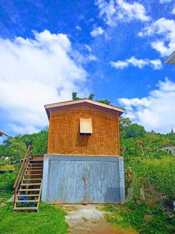 a small building with a ladder next to a gate at Rasta Rustic Off Grid Cabin in Gros Islet